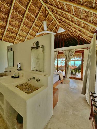 a bathroom with a sink and a bed in a room at Hotel CasaBakal - A pie de Laguna - Bacalar in Bacalar