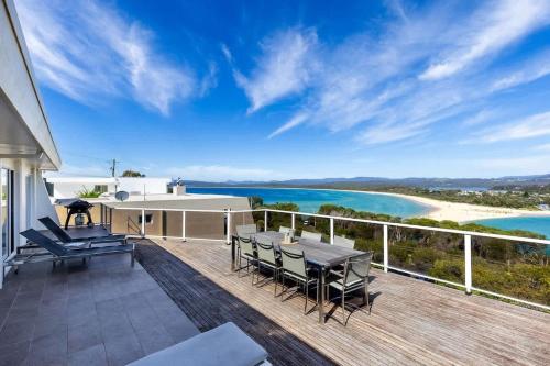 a deck with a view of the beach and the ocean at Bula Vista in Merimbula