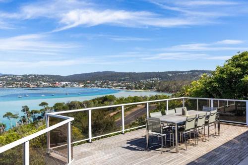 a balcony with a table and chairs and a view of the water at Bula Vista in Merimbula