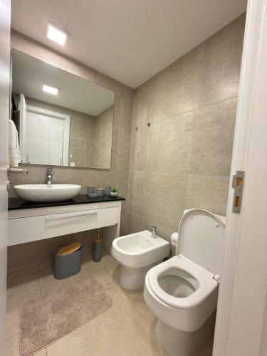 a bathroom with a white toilet and a sink at Feel Premiun 2401 in Asunción