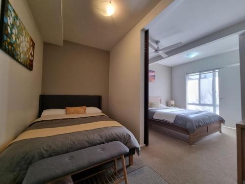 a bedroom with two beds and a window at Marley s Place in Queenscliff