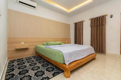 a bedroom with a bed in a room with a rug at Heyho Homestay Maluk in Maluk