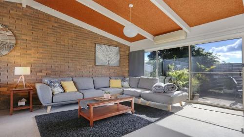 a living room with a couch and a table at PiPis on Collins in Merimbula