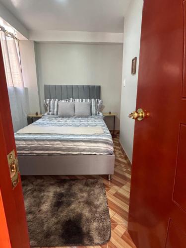 a bedroom with a bed and a red door at Wiracocha Apartments #2 in Pisac