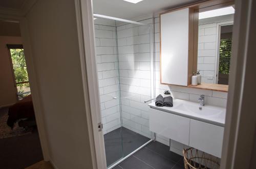 a white bathroom with a sink and a mirror at Monrepos in Point Lonsdale