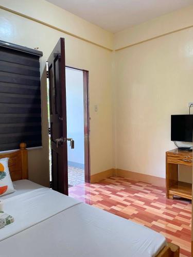 a bedroom with a bed and a tv and a window at Bocala Beach Resort in Balud