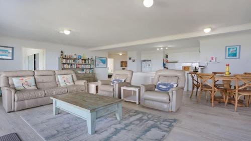a living room with a couch and chairs and a table at Quarterdeck 3 in Tura Beach