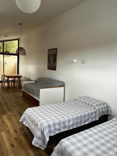 a bedroom with two beds and a dining room with a table at La Vicenta in Jesús María