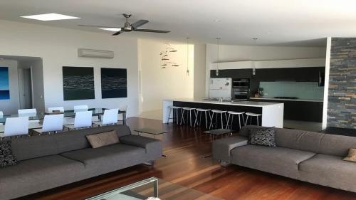 a living room with two couches and a kitchen at Turaroo in Tura Beach