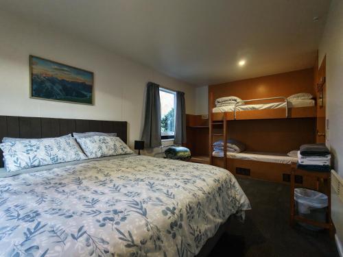 a bedroom with a bed and bunk beds at Zula Lodge in Wanaka