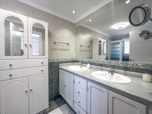a bathroom with two sinks and two mirrors at Sunset Marbella in Marbella