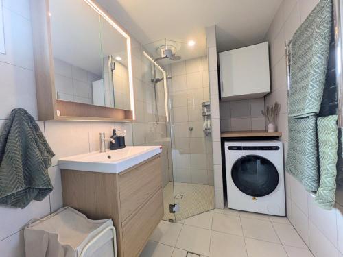 a bathroom with a washing machine and a sink at Elm's Deep Guest House in Berridale
