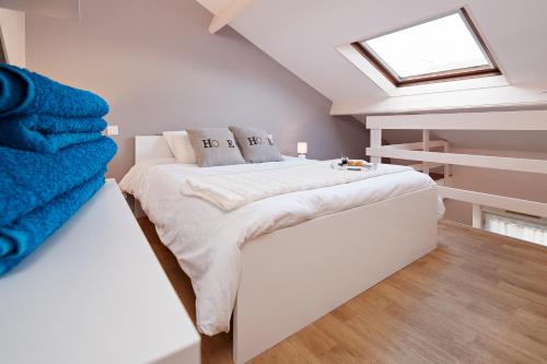 une chambre avec un lit blanc avec une lucarne dans l'établissement Au Coeur de Nantes Apartment, à Nantes