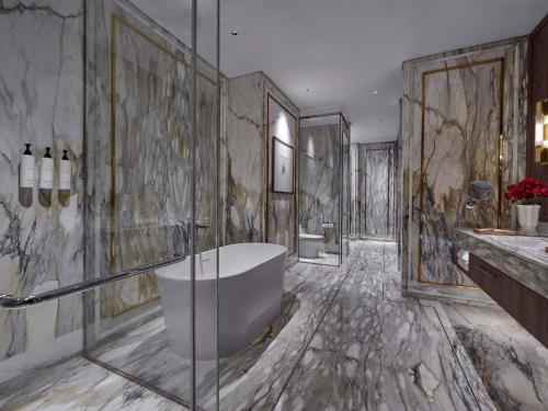 a large bathroom with a tub and a sink at Swissôtel Nusantara in Penajam