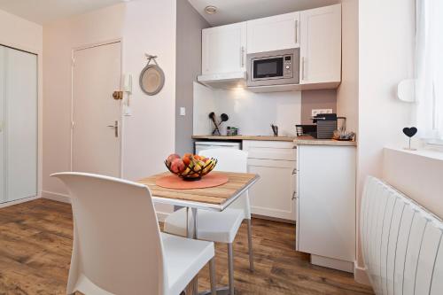 une cuisine avec une table avec un bol de fruits dessus dans l'établissement Au Coeur de Nantes Apartment, à Nantes