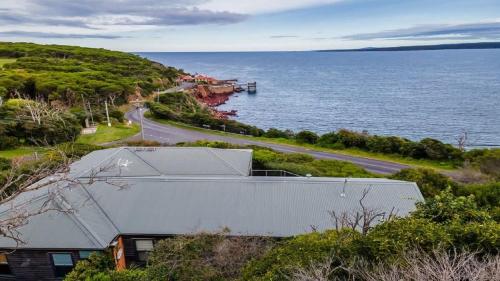 a house on a hill next to the ocean at Bantry Two in Merimbula