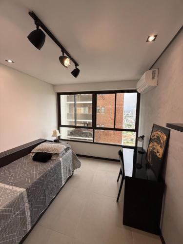a bedroom with a bed and a large window at Flat completo e aconchegante em Caruaru in Caruaru