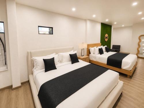 a hotel room with two beds with black and white pillows at The Hive Boutique Hotel Pool Suite 108 in Scarborough