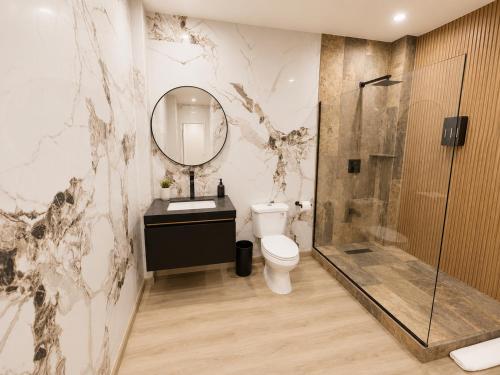 a bathroom with a toilet and a shower and a mirror at The Hive Boutique Hotel Pool Suite 108 in Scarborough