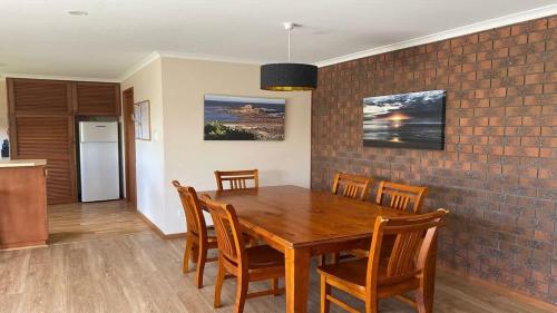 a dining room with a wooden table and chairs at Laura's Pambula Beach in Pambula Beach