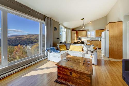 a living room with a white couch and a large window at 2CH - Fireplace Panoramic View - Upper Unit in Petite-Rivière-Saint-François