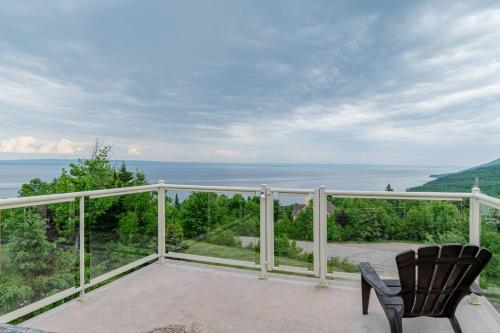 a balcony with two chairs and a view of the water at Panoramic View 2BR FP BBQ Terrace - Upper in Petite-Rivière-Saint-François