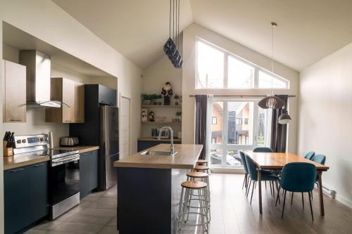 a kitchen with a table and chairs and a large window at 2CH Relaxation Spa Sauna BBQ Wi-Fi in Pont-Rouge