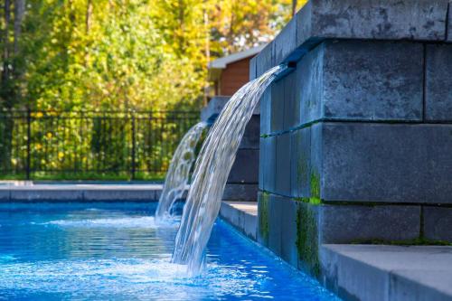 a water fountain in the middle of a pool at 2CH Relaxation Spa Sauna BBQ Wi-Fi in Pont-Rouge