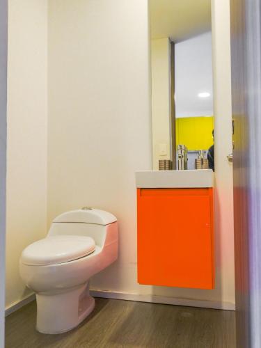 a bathroom with a toilet and a sink and a mirror at Espectacular Central Loft in Bogotá