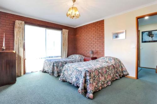 a hotel room with two beds and a window at SeaLeka 6 in Merimbula