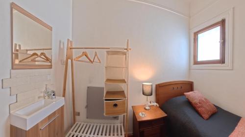 a small bedroom with a bed and a sink at Hostal Boutique Casa La Barca in Santiago