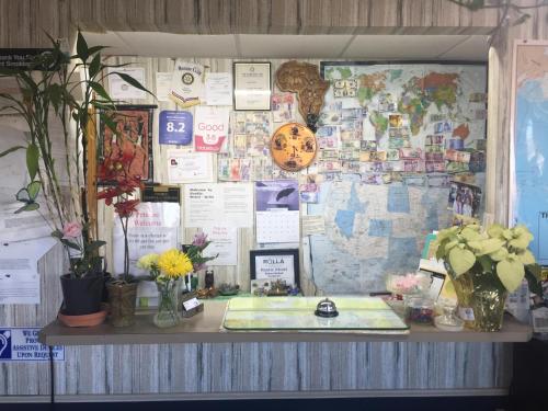 a bulletin board with a desk with flowers on it at Rustic Motel Rolla in Rolla
