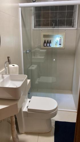 a bathroom with a toilet and a sink and a shower at Lara Country House in Guarulhos