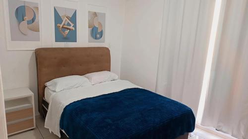 a bedroom with a bed with a blue blanket at Apto 5 pessoas - Prox FIP e Stop Shop in Brusque