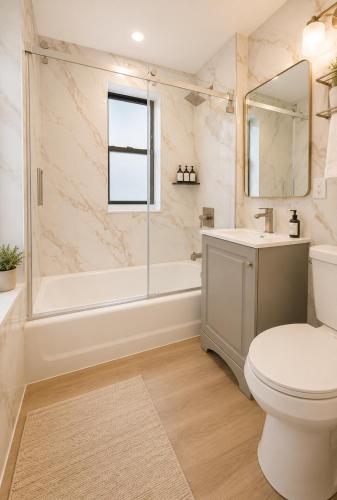 a bathroom with a toilet and a tub and a sink at Bay Ridge ApartHotel in Brooklyn