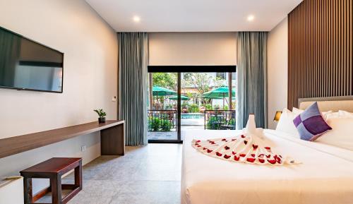 a hotel room with a bed with a fruit on it at The Sears Residence Siem Reap in Phumĭ Réach Born (2)