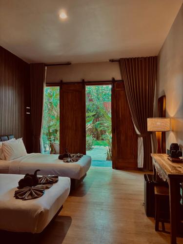 a hotel room with two beds and a large window at Home Dejavu in Gili Trawangan