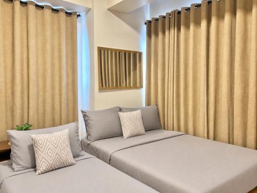 a room with two beds and a window with curtains at Spacious 2beds 1bedroom in Punta Engaño