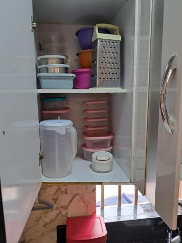 a kitchen cabinet filled with lots of bowls and utensils at Conexão Cariri in Juazeiro do Norte