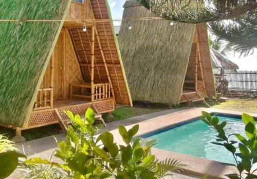a group of huts with a swimming pool at Mannor Beach Resort by Hiverooms in Carmen