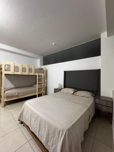 a bedroom with a bed and two bunk beds at Búnker de Coco in Pachacamac