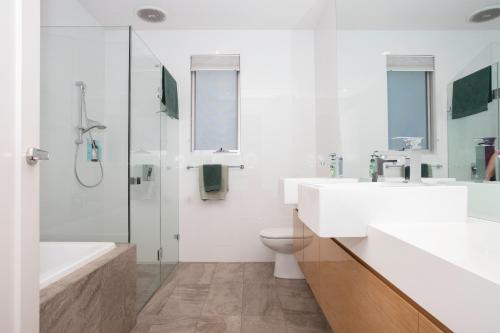 a bathroom with two sinks and a toilet and a shower at Margaret House | Elegant City-Fringe Escape in North Adelaide