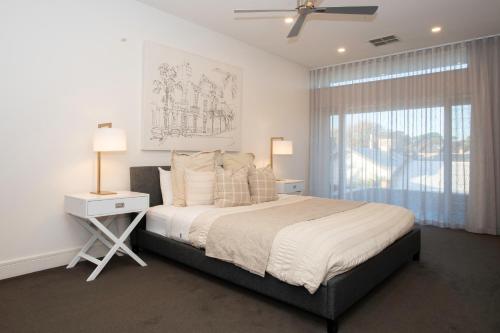 a bedroom with a large bed and a window at Margaret House | Elegant City-Fringe Escape in North Adelaide