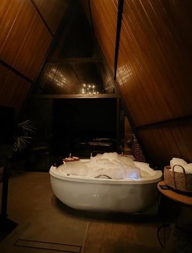 a bath tub sitting in the middle of a room at Refúgio romântico em Pirenópolis Chalé Ypê Branco Ypês da Serra in Pirenópolis
