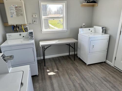 a laundry room with white appliances and a window at 1 Bed 1 Bath Suite On Strip in Geneva