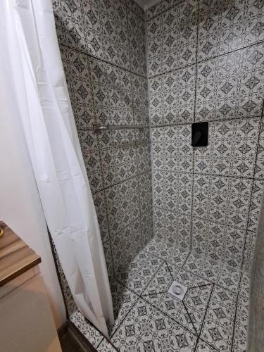 a shower with a gray and white tile floor at El Laurel in Chillán