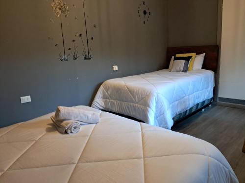 two beds in a hotel room with towels on them at El Laurel in Chillán