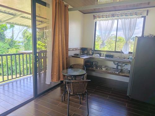 a kitchen with a sink and a balcony at INTUS Lodge Rio Celeste in El pilon