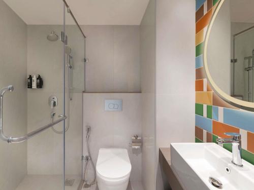 a bathroom with a toilet and a sink and a shower at ibis Mumbai BKC in Mumbai
