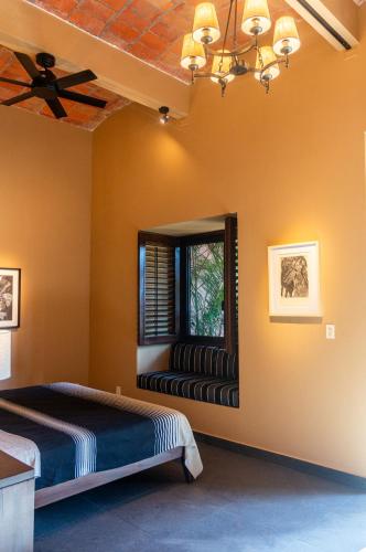 a bedroom with a bed and a window with a window seat at Red Tree Oaxaca in Oaxaca City